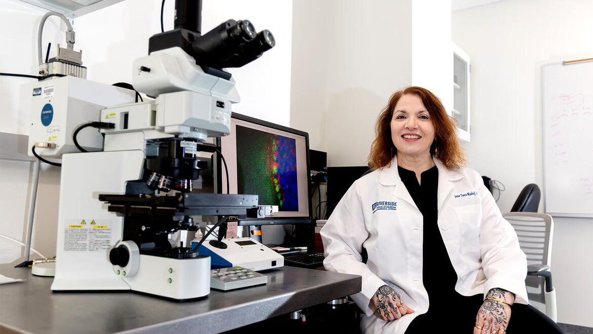 Seema Tiwarii Woodruff in front of a microscope