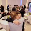 student hugging a family member