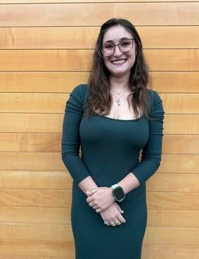 Samantha Assad standing in front of wooden paneling