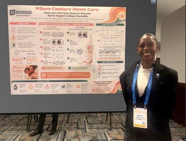 Mya Wells in front of her poster